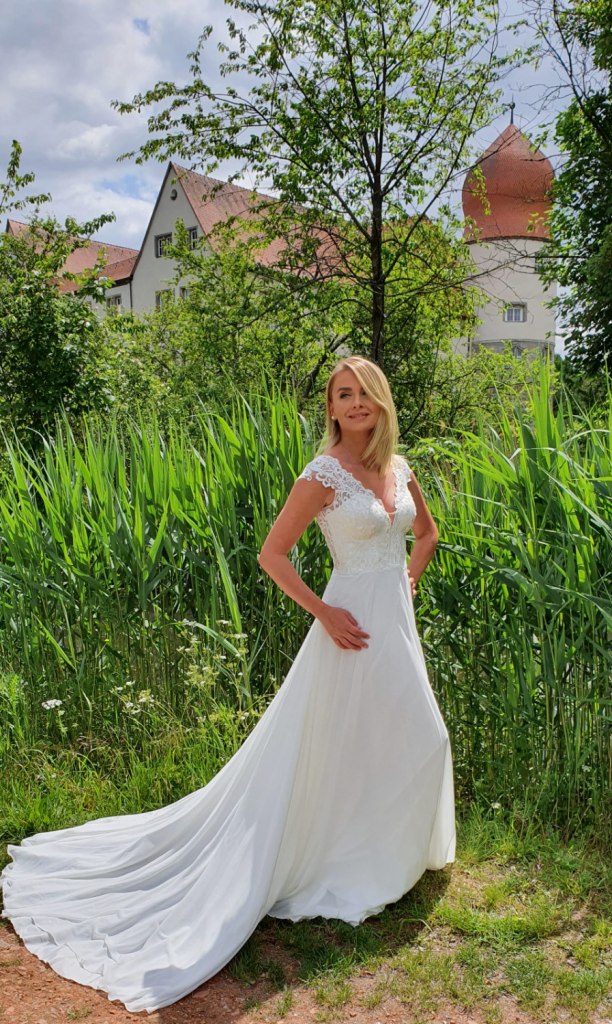 Ein bezauberndes Brautkleid mit romantischer Spitze und fließenden Stoffen.