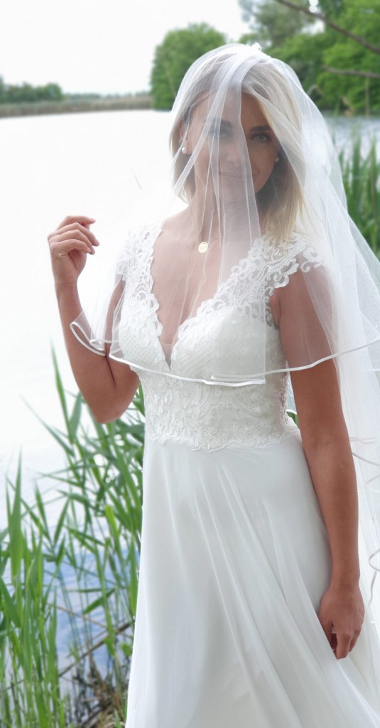 Der Schleier perfektioniert den klassischen Look des Brautkleides.