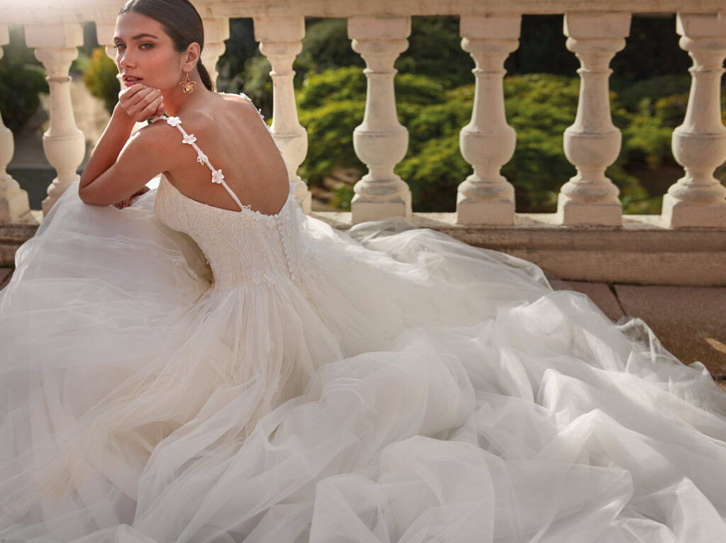 Brautmode Nürnberg – elegante Braut in einem romantischen Hochzeitskleid mit Tüllrock auf einer Terrasse mit klassischer Balustrade